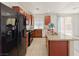 Bright kitchen featuring granite countertops, wooden cabinets, black appliances, and sliding glass door at 10469 Mulvaney Cir, Las Vegas, NV 89141