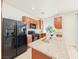 Kitchen showcasing black appliances, wooden cabinets, granite countertops, and tile flooring at 10469 Mulvaney Cir, Las Vegas, NV 89141