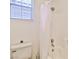 Bathroom featuring a white tub with shower curtain, toilet and window at 10667 Olympic Pine Dr, Las Vegas, NV 89135