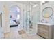 Bright bathroom featuring a marble shower with glass enclosure and a wood vanity at 10667 Olympic Pine Dr, Las Vegas, NV 89135