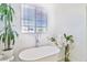 Bright bathroom featuring a freestanding tub with chrome fixtures and floral decor at 10667 Olympic Pine Dr, Las Vegas, NV 89135