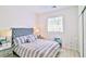 Bedroom featuring a tufted headboard, mirrored nightstands, and a large window at 10667 Olympic Pine Dr, Las Vegas, NV 89135