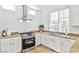 Close-up of kitchen, granite countertops, stainless steel appliances, and ample natural light at 10667 Olympic Pine Dr, Las Vegas, NV 89135