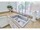 Stainless steel kitchen sink and faucet with granite countertops and window views at 10667 Olympic Pine Dr, Las Vegas, NV 89135