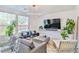 Bright living room featuring plush seating, modern lighting, and large windows overlooking the pool at 10667 Olympic Pine Dr, Las Vegas, NV 89135