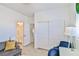 Bright living room with grey sofa, blue chairs, closet and ensuite bathroom at 10667 Olympic Pine Dr, Las Vegas, NV 89135