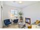 Bright living room with grey sofa, blue chairs, desk and potted plants at 10667 Olympic Pine Dr, Las Vegas, NV 89135