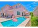 Backyard pool with spa and lounge features views of the two story home at 10667 Olympic Pine Dr, Las Vegas, NV 89135
