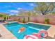 Backyard pool with spa and desert landscaping features fun inflatables and serene lounge area at 10667 Olympic Pine Dr, Las Vegas, NV 89135