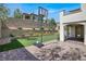 Backyard features lush green lawn, brick retaining wall, and brick paver patio with basketball hoop at 11856 Barona Mesa Ave, Las Vegas, NV 89138