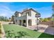 Backyard with synthetic lawn, brick paver patio with basketball hoop, and a two-story home at 11856 Barona Mesa Ave, Las Vegas, NV 89138