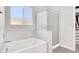 Bright bathroom featuring a shower over tub with glass doors and marble surround, offering a luxurious feel at 11856 Barona Mesa Ave, Las Vegas, NV 89138