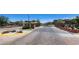 Community gate entrance surrounded by desert landscaping and red flowering shrubs at 11856 Barona Mesa Ave, Las Vegas, NV 89138