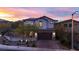 Charming two-story home with a tile roof and a well-manicured front yard against a colorful sunset backdrop at 11856 Barona Mesa Ave, Las Vegas, NV 89138
