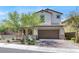 Inviting two-story home with a tile roof, a two-car garage, and lush landscaping in the front yard at 11856 Barona Mesa Ave, Las Vegas, NV 89138