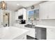 Bright kitchen with white cabinetry, stainless steel appliances, a farmhouse sink, and a view from the window at 11856 Barona Mesa Ave, Las Vegas, NV 89138
