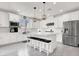 Modern kitchen featuring white cabinets, stainless steel appliances, an island with seating, and light wood flooring at 11856 Barona Mesa Ave, Las Vegas, NV 89138