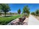 Neighborhood park featuring a bench surrounded by brick pavers, green grass, and desert landscaping at 11856 Barona Mesa Ave, Las Vegas, NV 89138