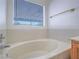 Close up on the soaking tub with tile surround in the primary bathroom at 1424 Heartstring Ct, Henderson, NV 89002