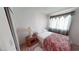 Comfortable bedroom featuring a cozy bed, side table with lamp, and a gray patterned curtain at 1745 Walingwood Dr, North Las Vegas, NV 89031