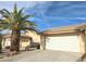 A well-maintained home exterior with a two-car garage, desert landscaping, and a towering palm tree at 2035 E Warm Springs Rd # 1017, Las Vegas, NV 89119
