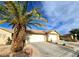 Charming home exterior with a two-car garage, surrounded by lush landscaping and mature trees at 2035 E Warm Springs Rd # 1017, Las Vegas, NV 89119