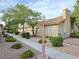 Exterior community street view with mature landscaping, sidewalk, lamp post, and neutral color scheme at 2035 E Warm Springs Rd # 1017, Las Vegas, NV 89119