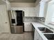 Well-lit kitchen with stainless steel refrigerator, quartz countertops, and stylish backsplash at 2035 E Warm Springs Rd # 1017, Las Vegas, NV 89119