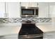 Modern kitchen features stainless steel range, built-in microwave, and a contemporary backsplash at 2035 E Warm Springs Rd # 1017, Las Vegas, NV 89119