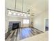 Open-concept living room featuring fireplace, updated light fixtures, and wood flooring at 2035 E Warm Springs Rd # 1017, Las Vegas, NV 89119