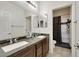 Bathroom features dual sinks, and a step in shower with dark tiling at 2117 Leatherbridge Ct, North Las Vegas, NV 89081