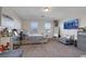 Carpeted bedroom with large bed, dresser, mounted TV, window coverings and light neutral walls at 2117 Leatherbridge Ct, North Las Vegas, NV 89081