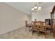 A dining room features an ornate chandelier illuminating a wooden dining set and tile flooring at 2117 Leatherbridge Ct, North Las Vegas, NV 89081