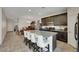 A kitchen features an island with barstool seating and dark wood cabinets that complement the dining room at 2117 Leatherbridge Ct, North Las Vegas, NV 89081