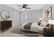 Nicely staged bedroom features modern furniture, carpet, windows, ceiling fan, and decor at 230 Mission Newport Ln # 104, Las Vegas, NV 89107