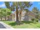 Exterior view of condo buildings with well-maintained lawn and mature trees at 230 Mission Newport Ln # 104, Las Vegas, NV 89107