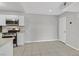 Open kitchen with white cabinets, modern appliances, and tile flooring at 230 Mission Newport Ln # 104, Las Vegas, NV 89107
