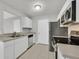 Contemporary kitchen showcasing white cabinets, stainless steel appliances, tile floors, and ample counter space at 230 Mission Newport Ln # 104, Las Vegas, NV 89107