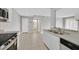 Open kitchen features stainless steel appliances, white cabinets, tile flooring, and bar seating at 230 Mission Newport Ln # 104, Las Vegas, NV 89107