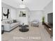 Digitally staged living room with modern furniture and bright, neutral tones at 230 Mission Newport Ln # 104, Las Vegas, NV 89107
