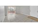 Bright condo living space with tiled floors and sliding door access to a balcony at 230 Mission Newport Ln # 104, Las Vegas, NV 89107