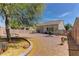 Landscaped backyard with stone accents, desert plants, rock ground cover, and a small patio area at 2304 Willow Wren Dr, North Las Vegas, NV 89084