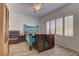 Inviting bedroom featuring wood-look tile flooring, ceiling fan, and bright natural light at 2304 Willow Wren Dr, North Las Vegas, NV 89084