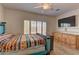 Bright bedroom featuring a ceiling fan, wood-look flooring, and a window with plantation shutters at 2304 Willow Wren Dr, North Las Vegas, NV 89084