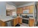 Modern kitchen with wood cabinets, stainless appliances, and an open bar view to the dining area at 2304 Willow Wren Dr, North Las Vegas, NV 89084