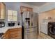 Bright kitchen featuring modern appliances, a laundry closet, and an adjacent refrigerator at 2304 Willow Wren Dr, North Las Vegas, NV 89084