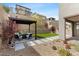 Inviting backyard with a pergola-covered seating area, artificial grass, and stone pathway leading to a well-maintained landscape at 2367 Ridgeline Wash St, Las Vegas, NV 89138