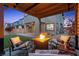 Relaxing backyard seating area with a fire pit, complemented by lush landscaping and a covered patio at 2367 Ridgeline Wash St, Las Vegas, NV 89138