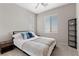 A light-filled bedroom features a ceiling fan, a bed with blue pillows, and a decorative shelf at 2367 Ridgeline Wash St, Las Vegas, NV 89138