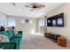 The bonus room features a comfortable green sofa, large tv, and balcony access for seamless indoor/outdoor living at 2367 Ridgeline Wash St, Las Vegas, NV 89138